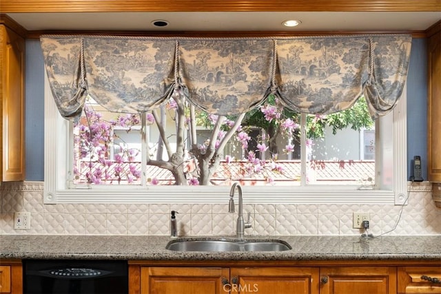 interior space with decorative backsplash, a sink, black dishwasher, and brown cabinets