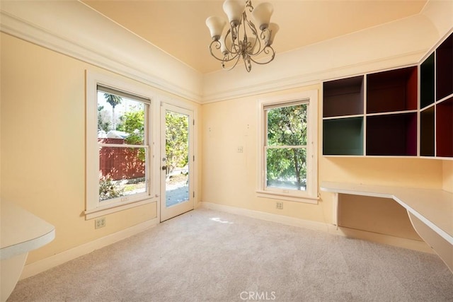 unfurnished dining area featuring baseboards, carpet floors, and a notable chandelier