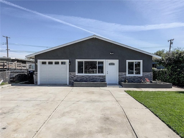 view of front of house featuring stone siding, driveway, and stucco siding