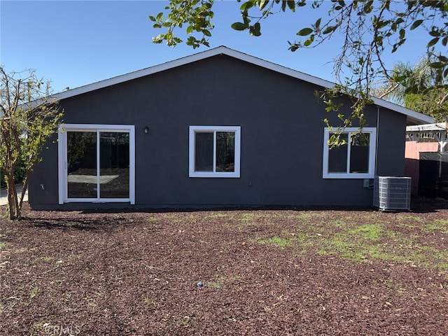 back of property with central air condition unit and stucco siding