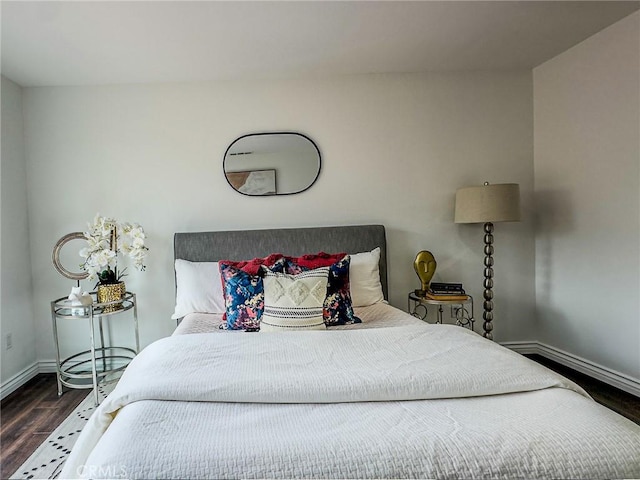 bedroom with baseboards and wood finished floors