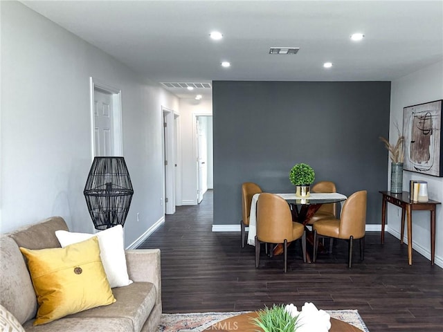 dining space featuring visible vents, baseboards, and wood finished floors