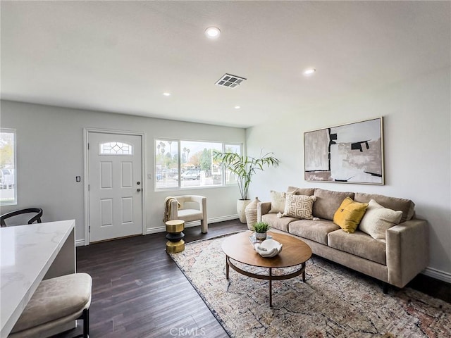 living area featuring baseboards, dark wood-style flooring, visible vents, and recessed lighting