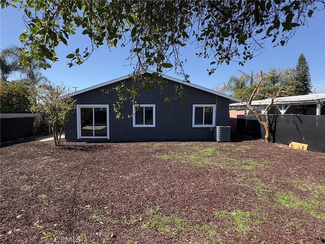 rear view of house featuring central AC and a fenced backyard