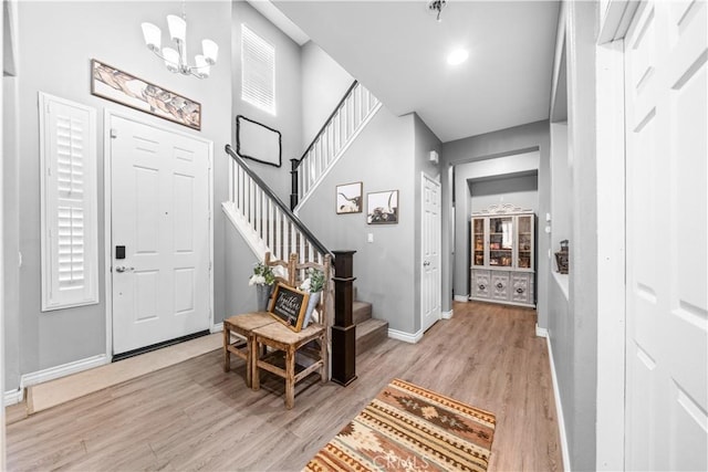 entrance foyer featuring light wood-style floors, stairway, and baseboards