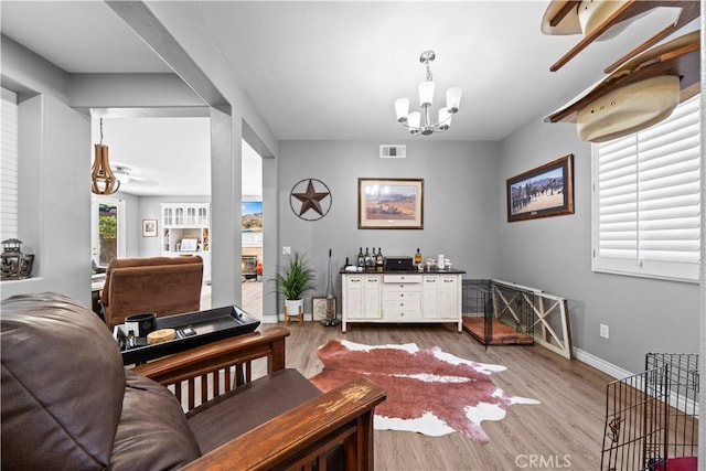 dining area with visible vents, a notable chandelier, baseboards, and wood finished floors