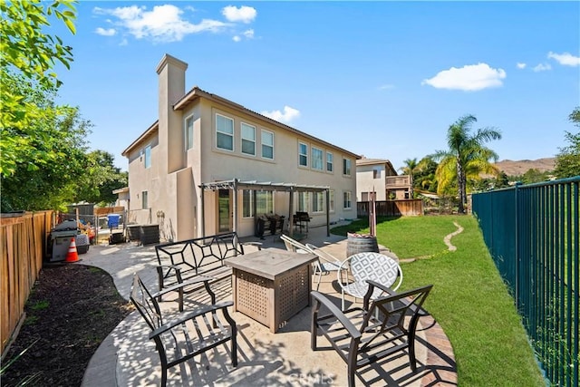 rear view of house with a pergola, a fenced backyard, a patio, and stucco siding