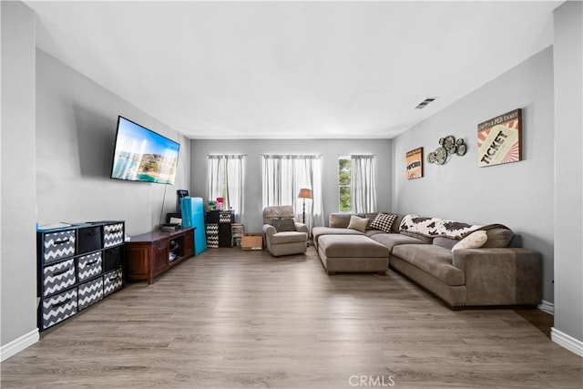 living room featuring visible vents, baseboards, and wood finished floors