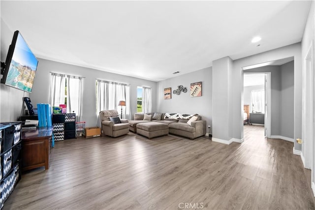 living room with wood finished floors, visible vents, and baseboards