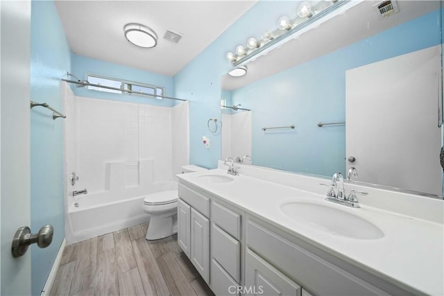 bathroom with toilet, visible vents, and a sink