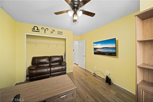 living room with dark wood-style floors, ceiling fan, and baseboards