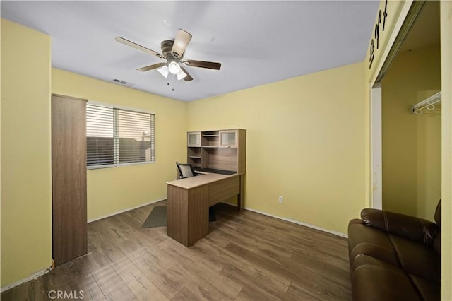 home office featuring a ceiling fan, visible vents, and dark wood finished floors