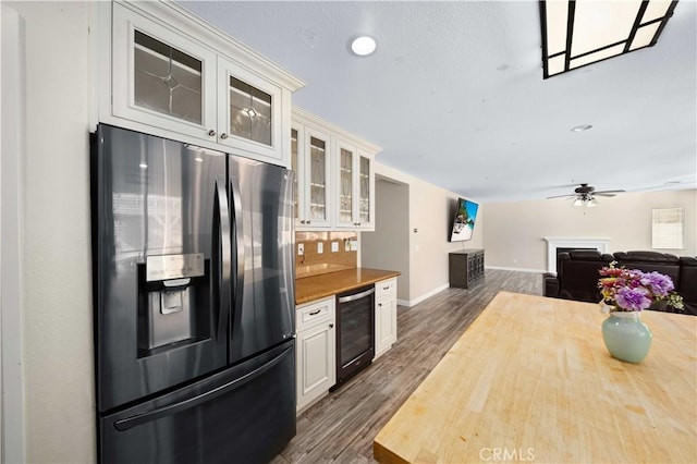 kitchen featuring beverage cooler, wood counters, a fireplace, and stainless steel fridge with ice dispenser