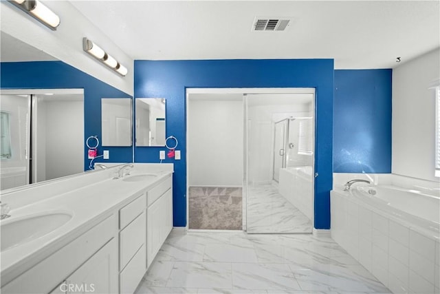 full bathroom with a bath, marble finish floor, visible vents, and a sink