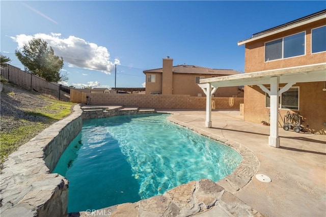 view of swimming pool featuring a patio area, a fenced backyard, and a pool with connected hot tub