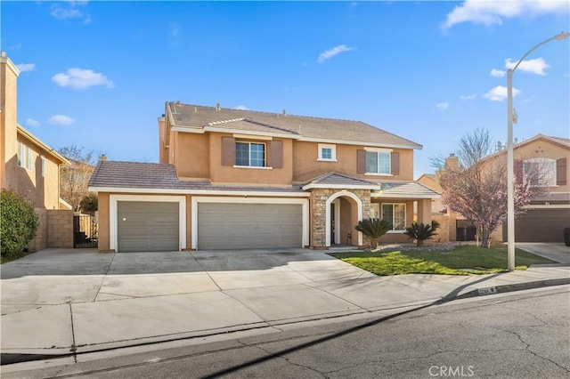 traditional-style home with an attached garage, fence, concrete driveway, a tiled roof, and stucco siding