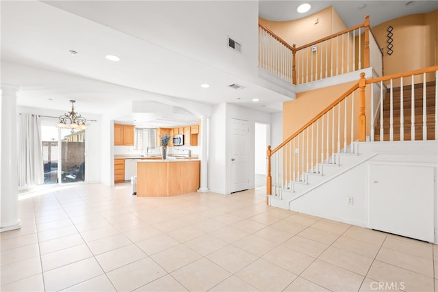 unfurnished living room with recessed lighting, visible vents, stairs, ornate columns, and light tile patterned flooring