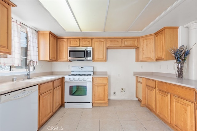 kitchen with light tile patterned floors, light countertops, white appliances, and a sink