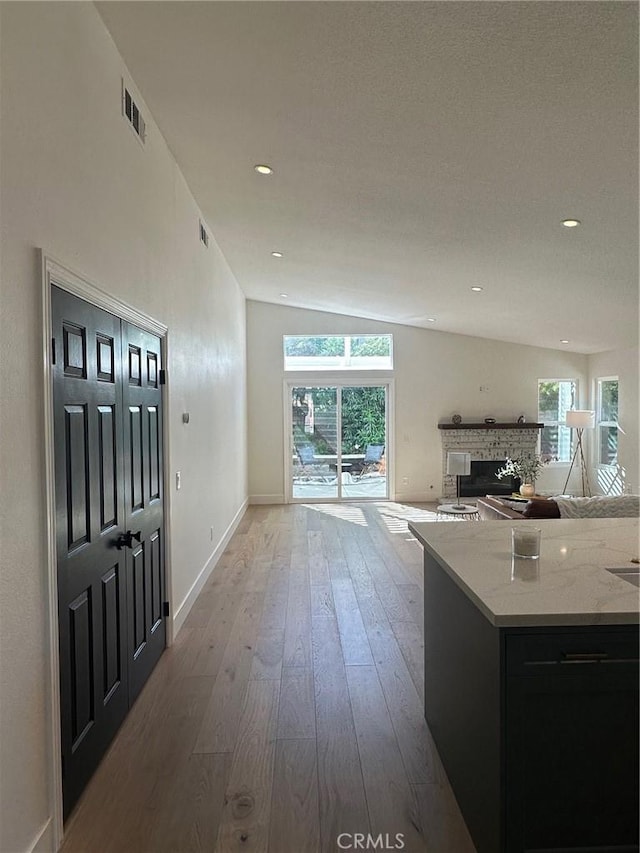 37211 Jerome Ln, Murrieta, CA 92562 - kitchen with lofted ceiling, hardwood / wood-style floors, a fireplace, open floor plan, and baseboards