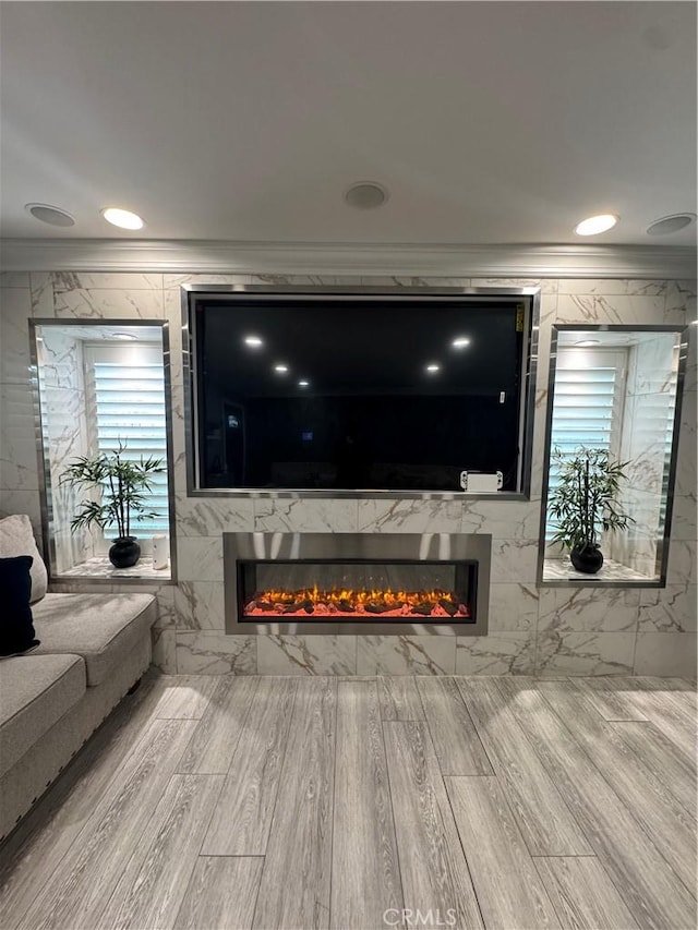 living area with ornamental molding, recessed lighting, and a premium fireplace