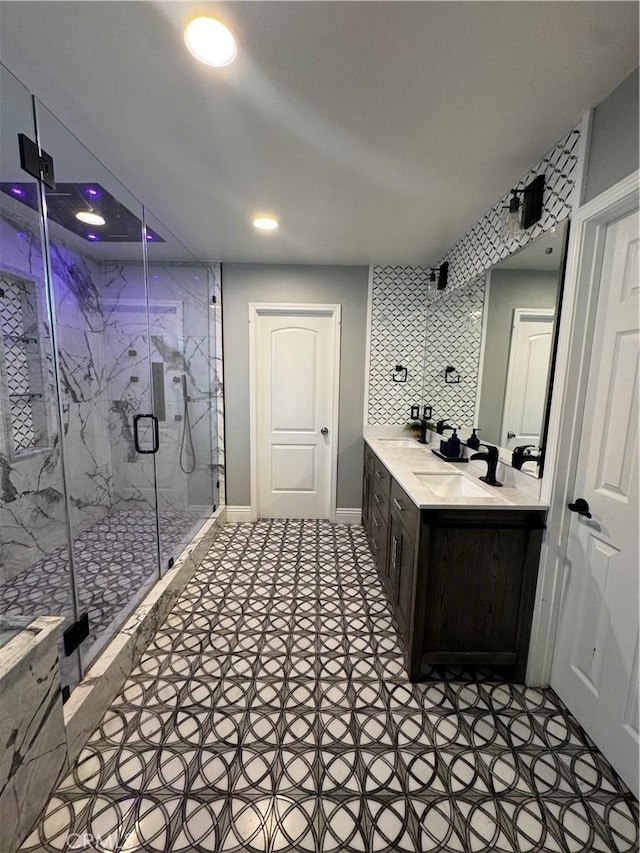 bathroom featuring baseboards, a marble finish shower, vanity, and recessed lighting