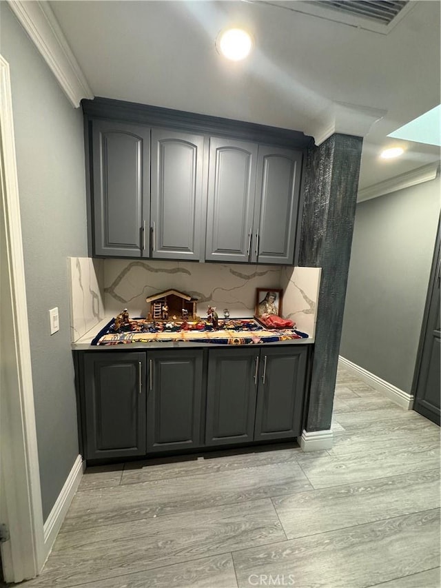 bar featuring light wood-style flooring, recessed lighting, visible vents, baseboards, and crown molding