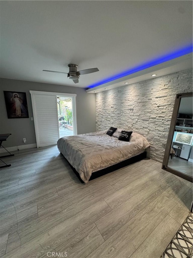 bedroom featuring ceiling fan, baseboards, and wood finished floors