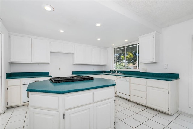 kitchen featuring black stovetop, white dishwasher, white cabinets, and a sink