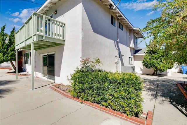 view of property exterior featuring central air condition unit, a patio area, and stucco siding