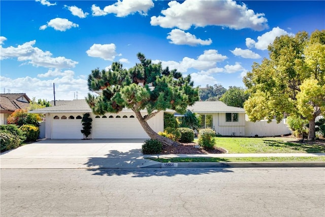 view of front of property featuring a front yard, concrete driveway, and an attached garage