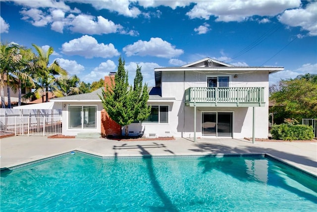 back of house with a fenced in pool, a patio, a balcony, fence, and stucco siding