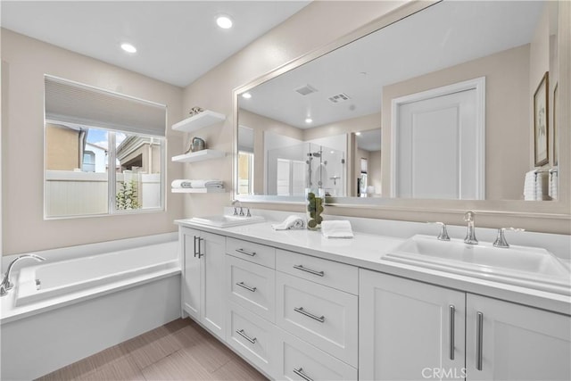 bathroom with double vanity, a shower stall, visible vents, and a sink
