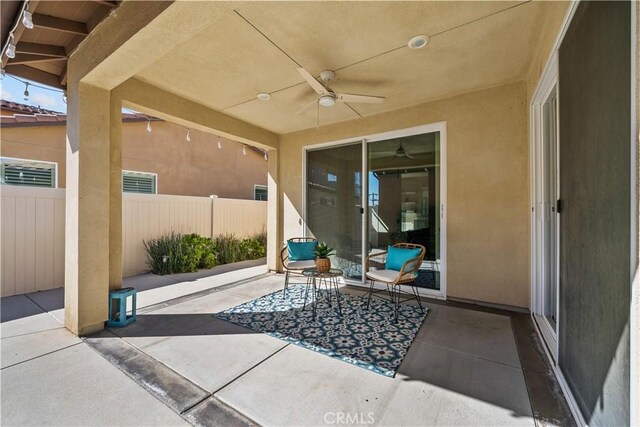 view of patio with fence and a ceiling fan