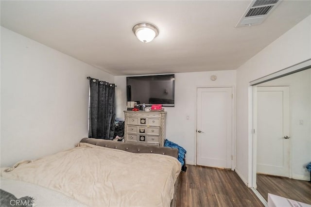 bedroom with baseboards, visible vents, and dark wood-type flooring