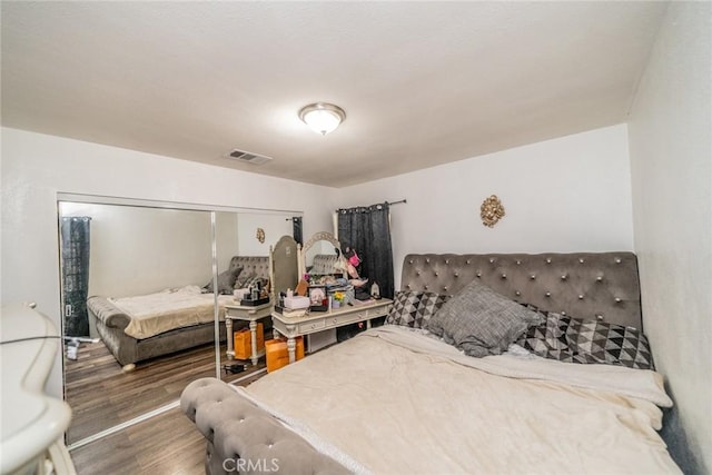 bedroom featuring visible vents and wood finished floors