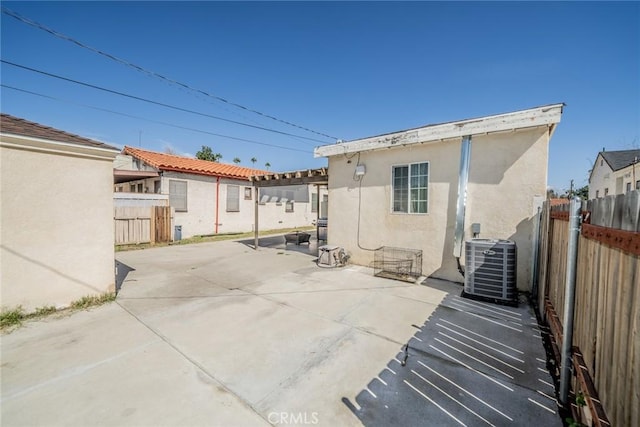 back of house with central AC, a patio area, fence, and stucco siding