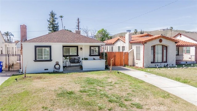 view of front of home featuring crawl space, fence, a front lawn, and stucco siding