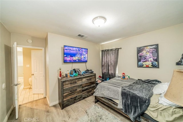 bedroom with visible vents, baseboards, and wood finished floors