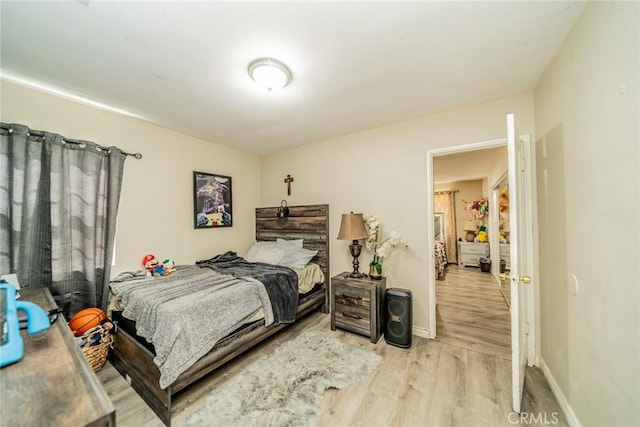 bedroom featuring baseboards and light wood finished floors