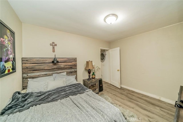 bedroom featuring baseboards and wood finished floors