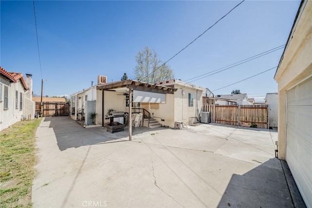 back of house with a patio area, a fenced backyard, and central AC