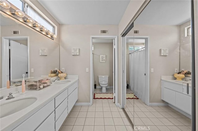 full bathroom with double vanity, visible vents, a sink, and tile patterned floors