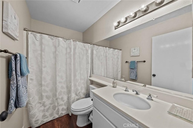 bathroom featuring curtained shower, vanity, toilet, and wood finished floors