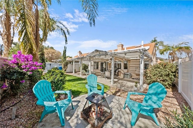 back of property with a fenced backyard, a fire pit, a pergola, and a patio