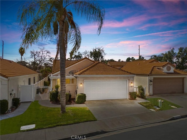 view of front of house with a gate, fence, a garage, driveway, and a tiled roof