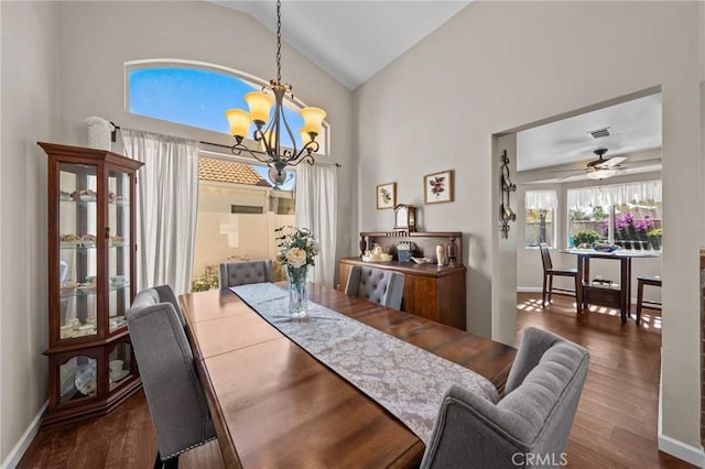 dining area with ceiling fan with notable chandelier, wood finished floors, visible vents, and baseboards