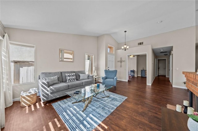 living area featuring lofted ceiling, a brick fireplace, dark wood finished floors, and visible vents