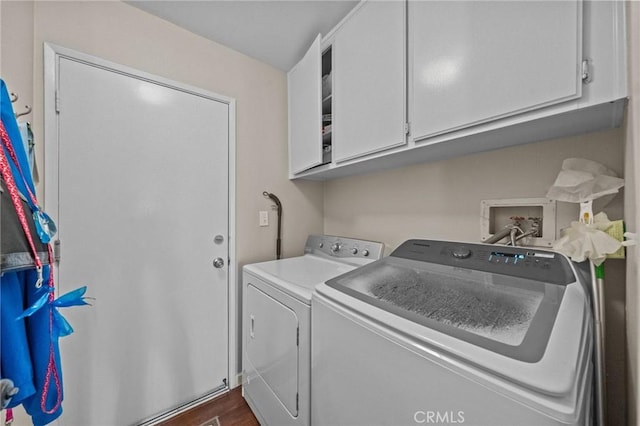 laundry area with dark wood-style floors, cabinet space, and washer and dryer