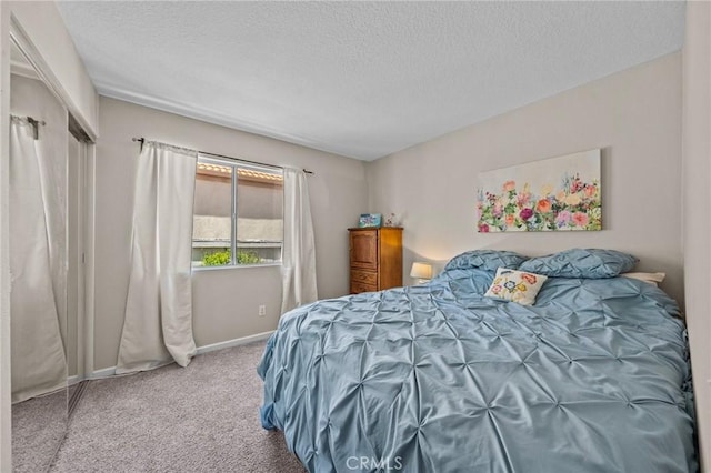 carpeted bedroom featuring baseboards and a textured ceiling