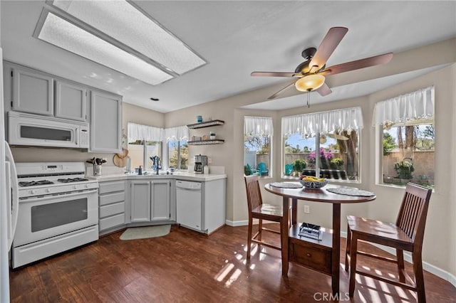 kitchen featuring open shelves, gray cabinets, light countertops, dark wood-type flooring, and white appliances